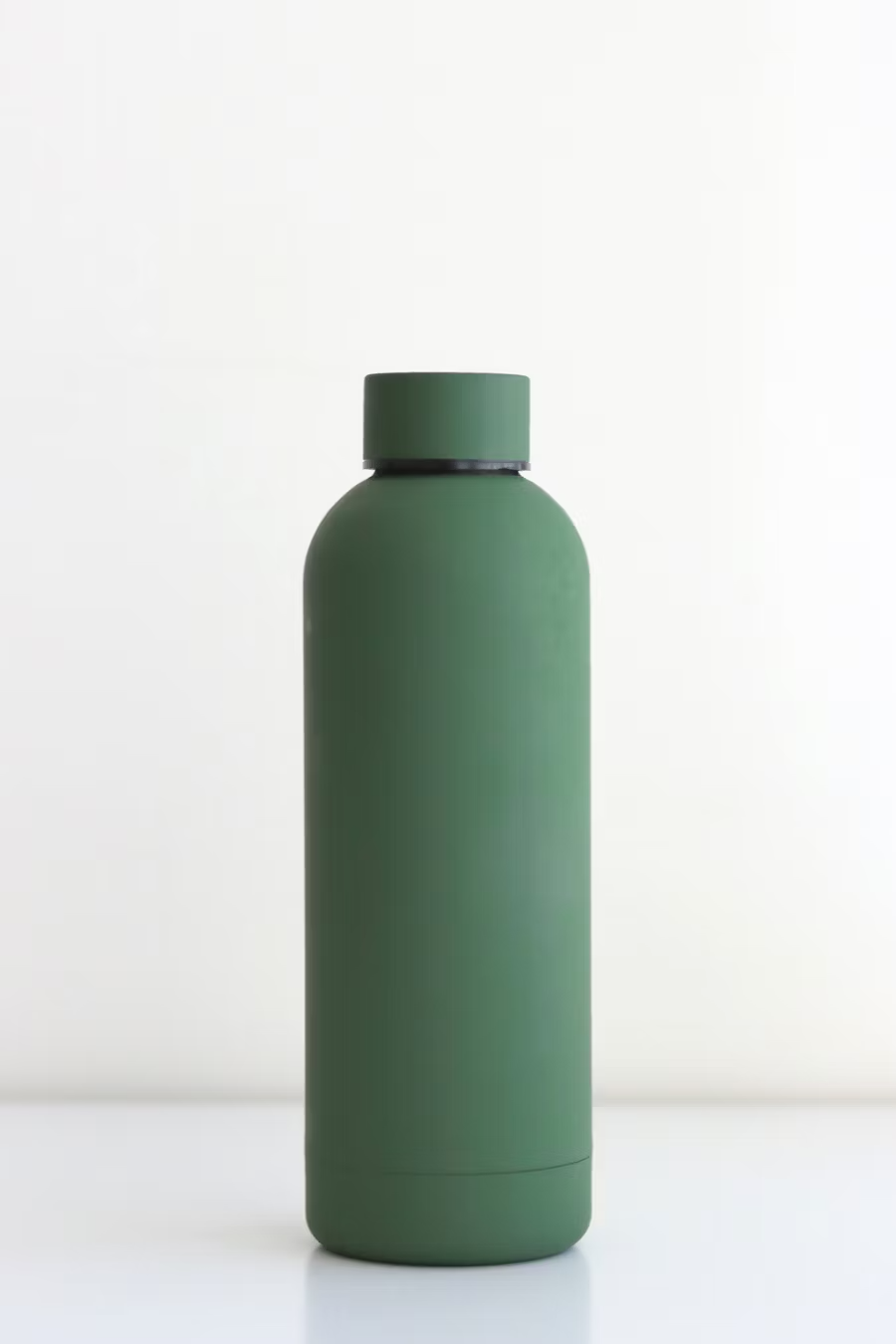 Green unbranded water bottle against a white wall