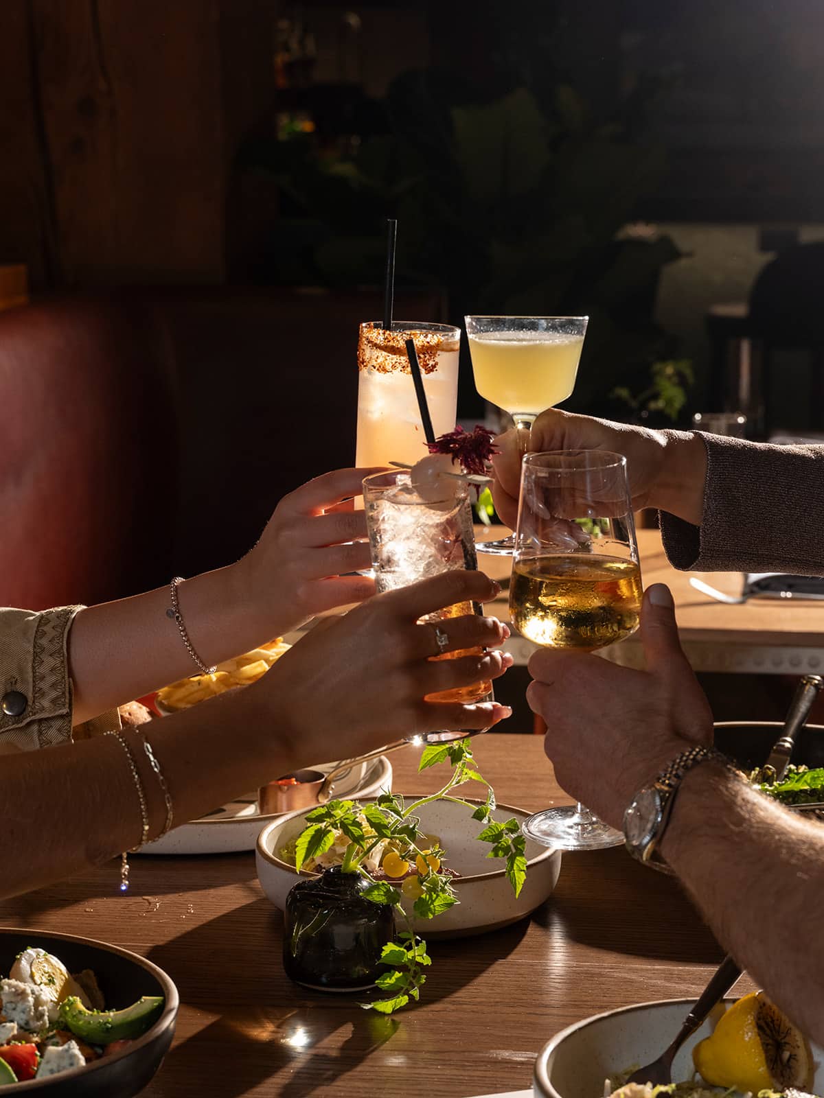 Group of people toasting their cocktails at Salt Harvest